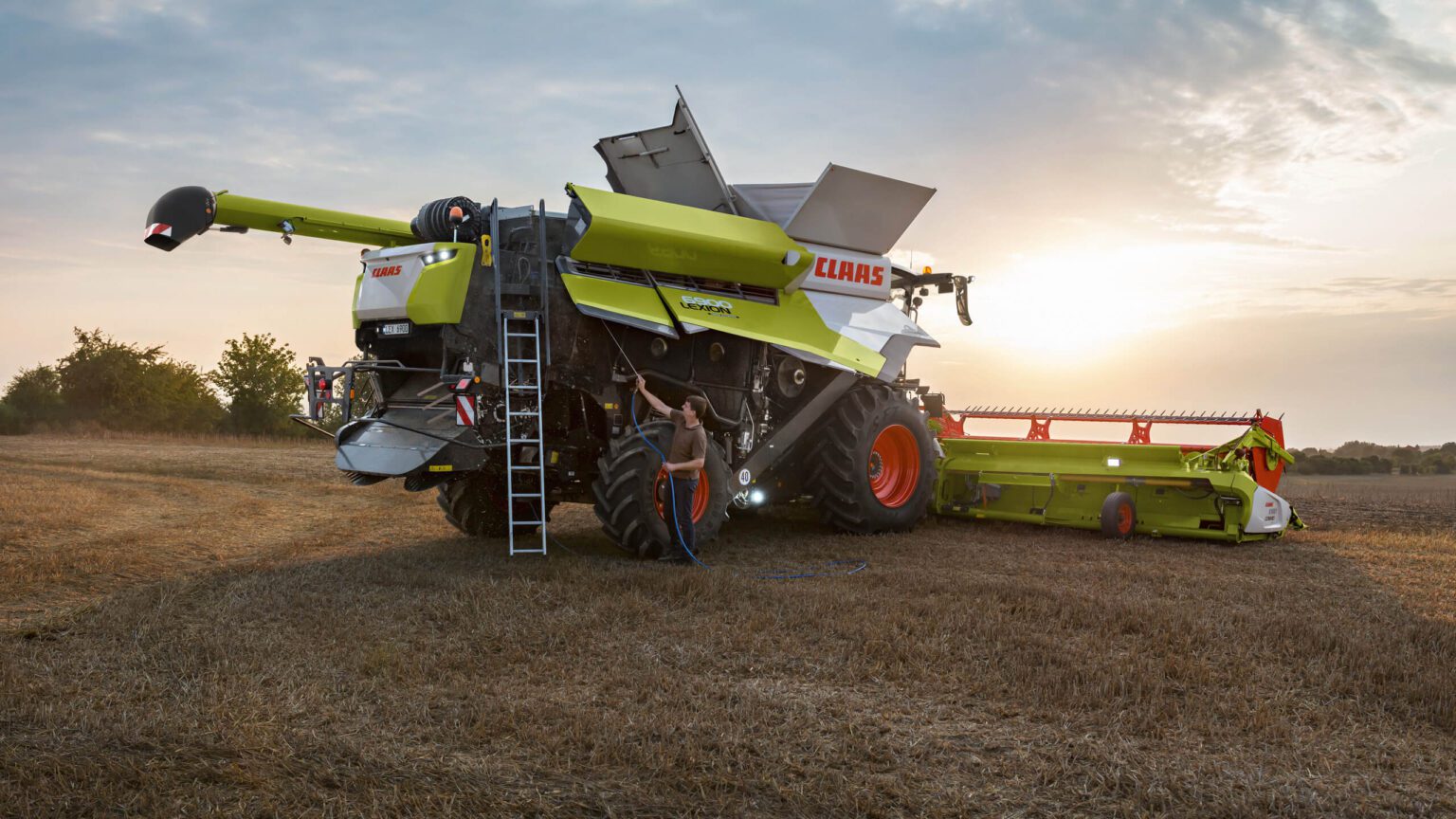 Θεριζοαλωνιστική CLAAS LEXION στο χωράφι, την ώρα που δύει ο ήλιος